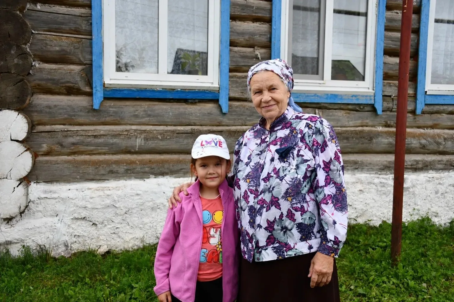 Жительница Большого Елoва с девочкой возле дома